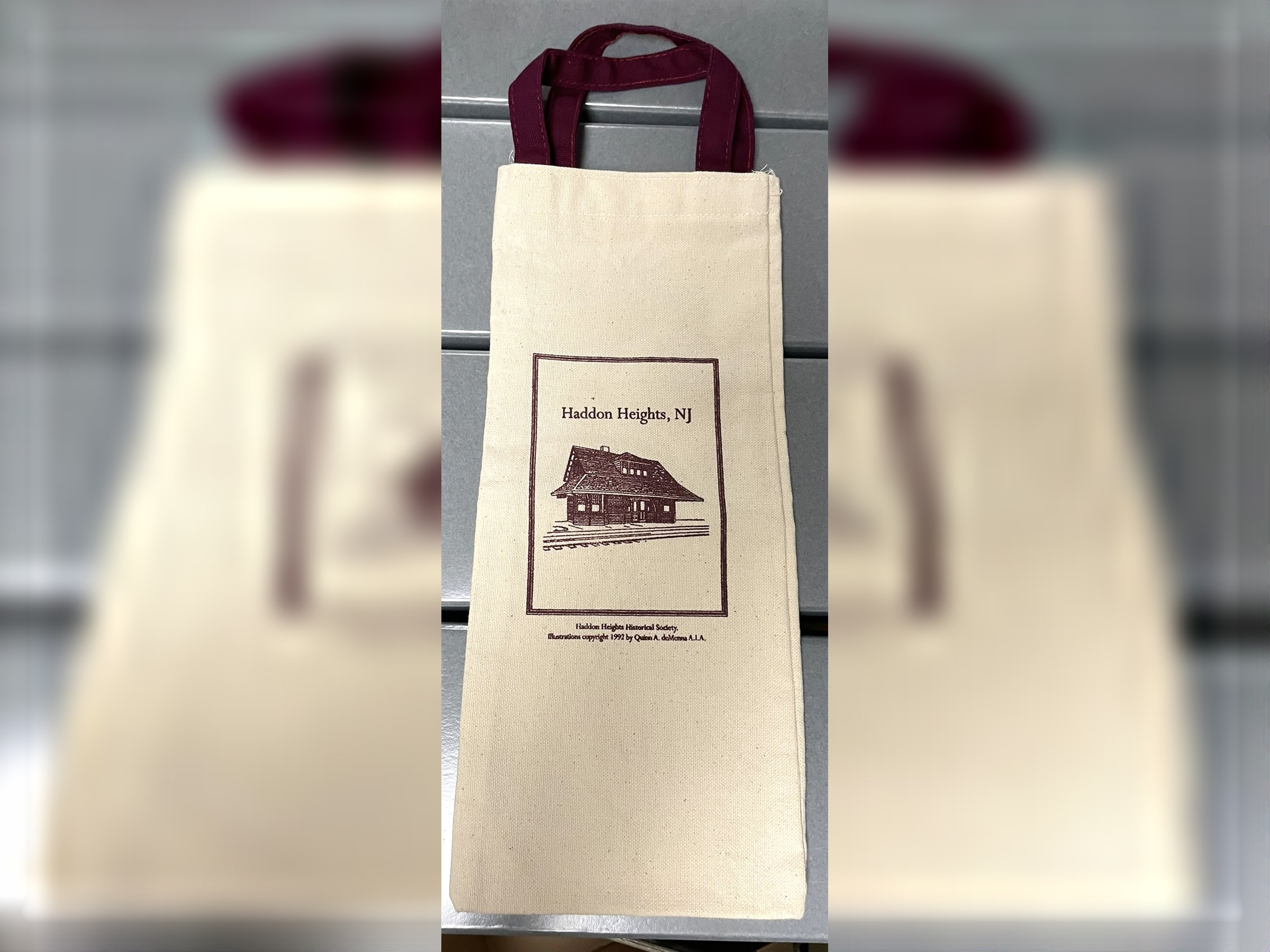 Cream-colored Haddon Heights wine tote with burgundy handles and a historic railroad station illustration